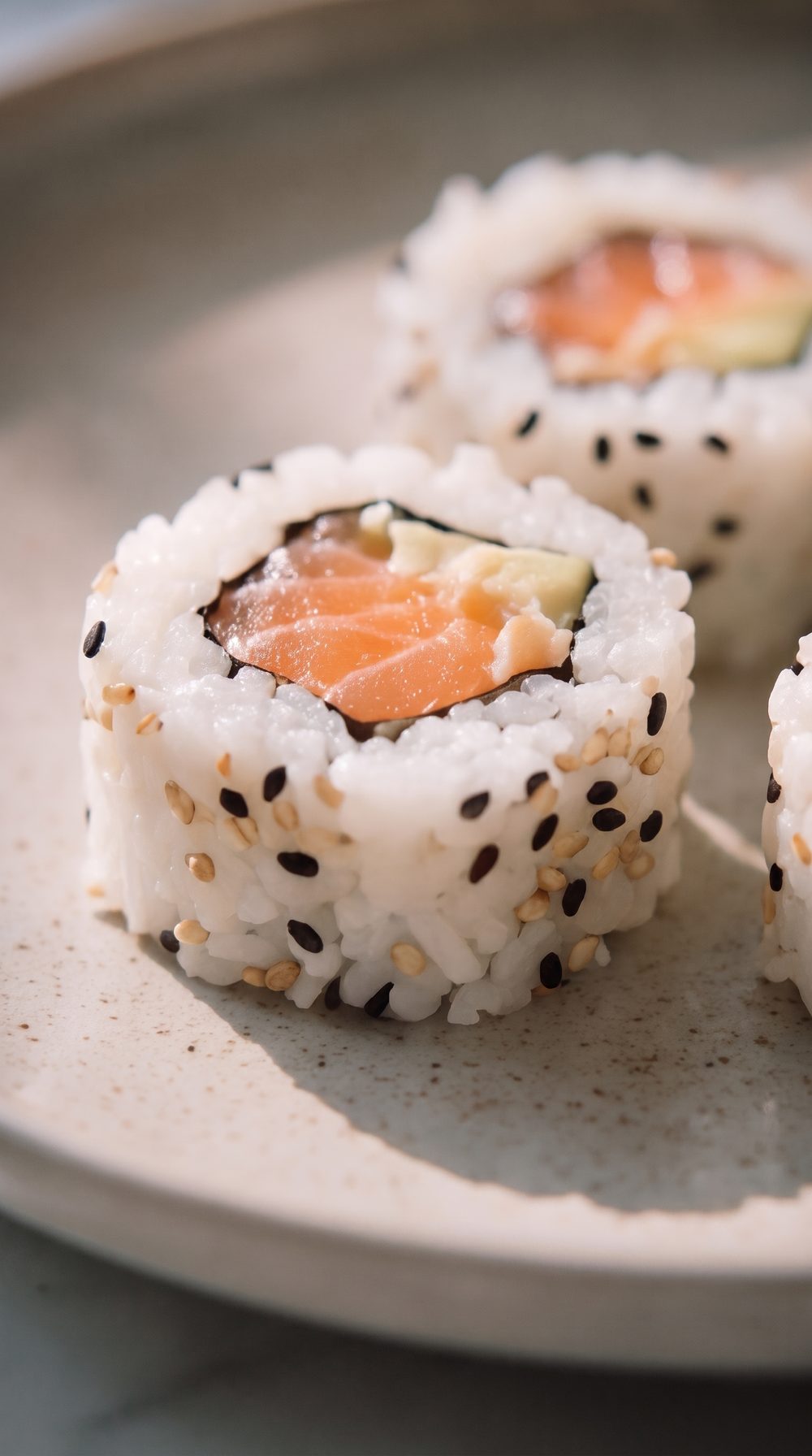 Primer plano de un roll de sushi de trucha con sésamo